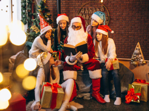 Santa claus reading a book to a group of kids